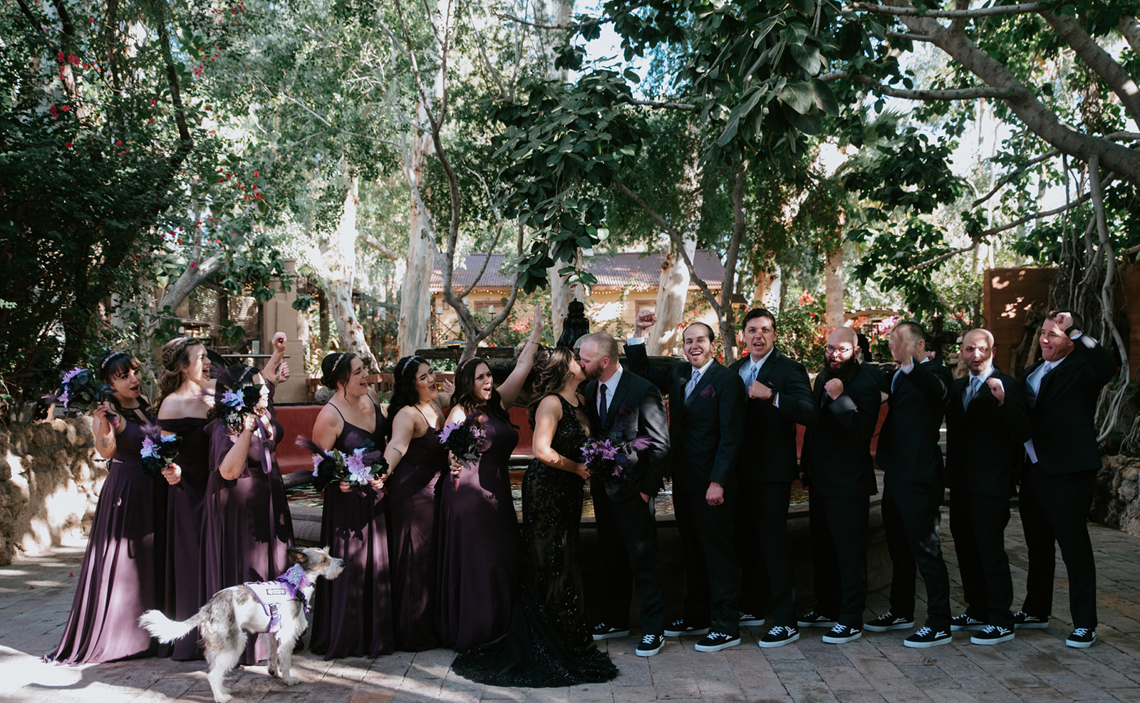 Wedding party cheering together with the couple during fun group portraits.
