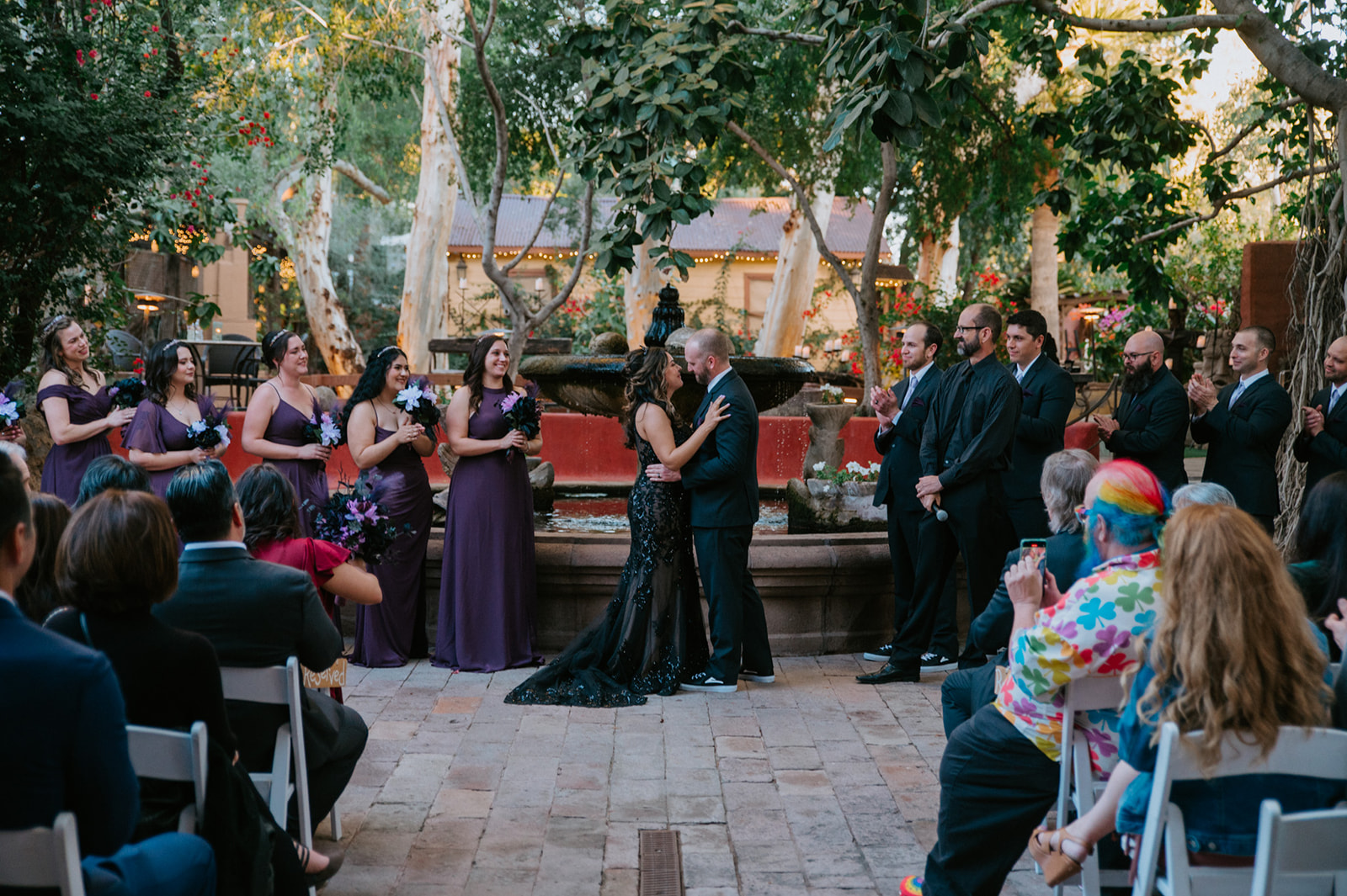 Newlyweds sharing their first kiss after exchanging vows at boojum tree hidden gardens.
