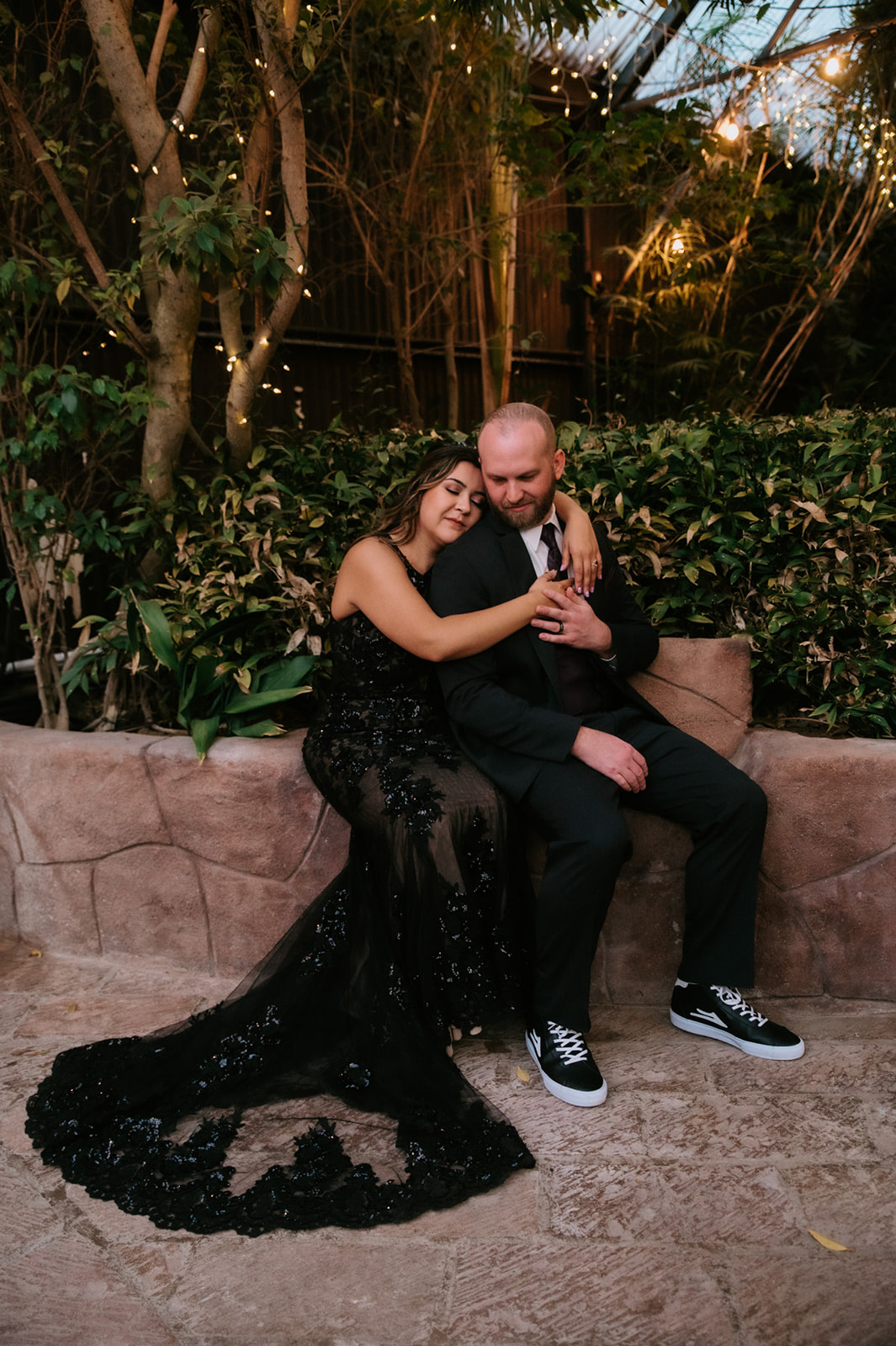 Bride resting her head on the groom's shoulder during intimate evening portraits at boojum tree hidden gardens.
