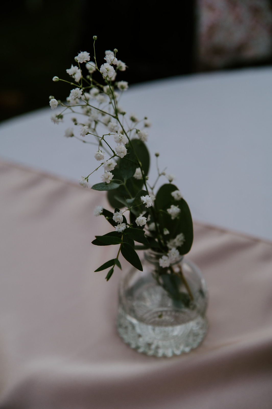 Small floral arrangement in a glass vase on a ceremony table during an intimate elopement with family