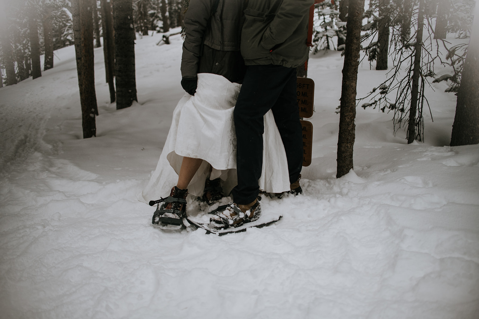 Detail shot of couple standing close in snowshoes after exchanging vows in winter conditions