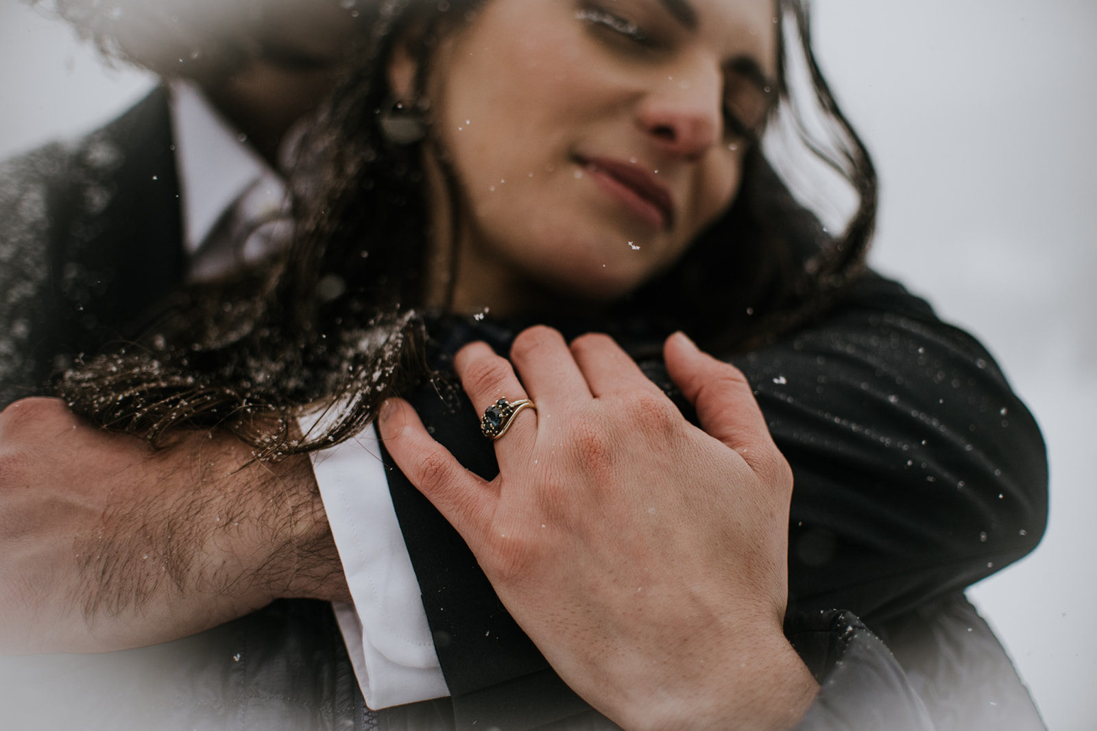 Couple kissing in falling snow during a winter elopement in Rocky Mountain National Park