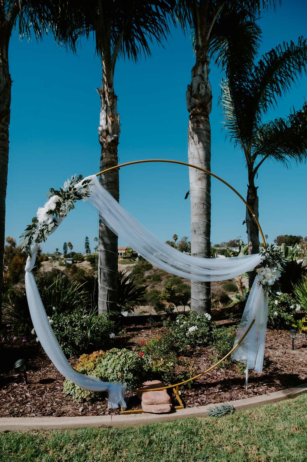 Circular ceremony arch decorated with flowing fabric and florals, styled for a family-centered elopement celebration in California.