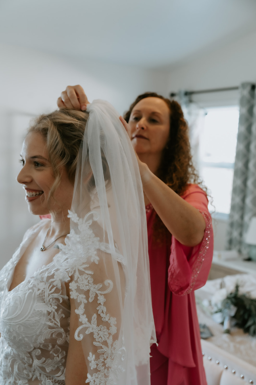 Bride getting ready with her mom helping adjust her veil inside an Airbnb, showing how to plan an elopement with family in an intimate, meaningful way.