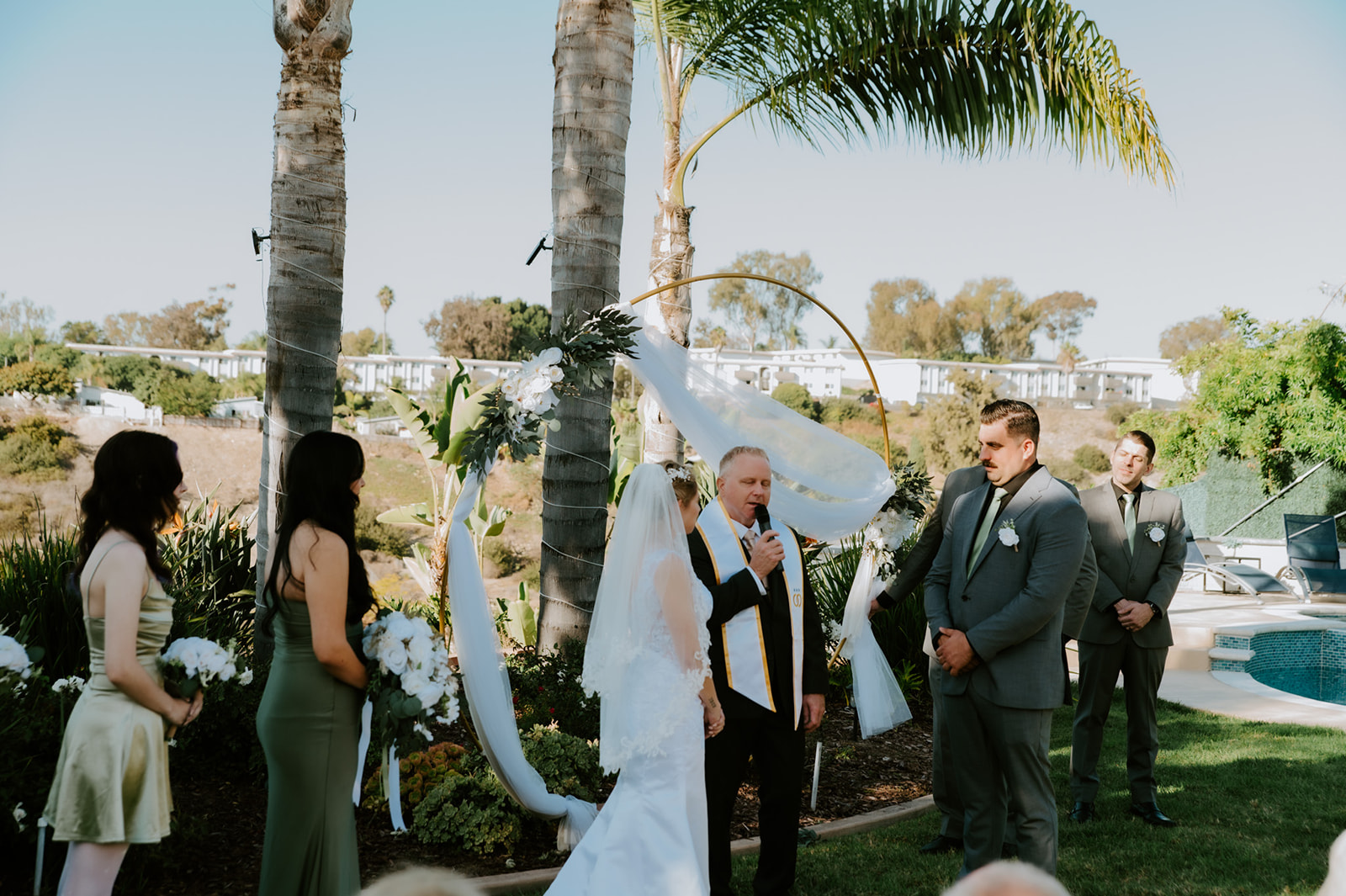 Bride and groom standing together during their intimate Airbnb ceremony with close family present.