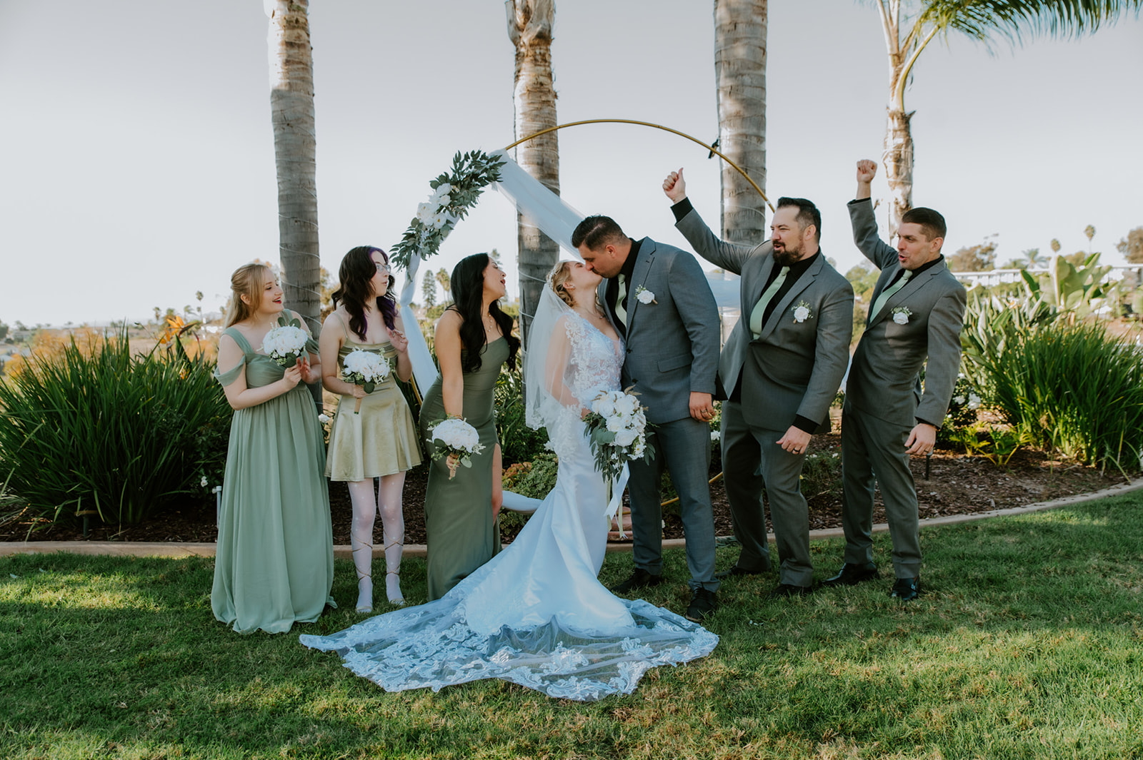 Wedding party cheering as the couple kisses during a joyful Airbnb wedding ceremony in California.
