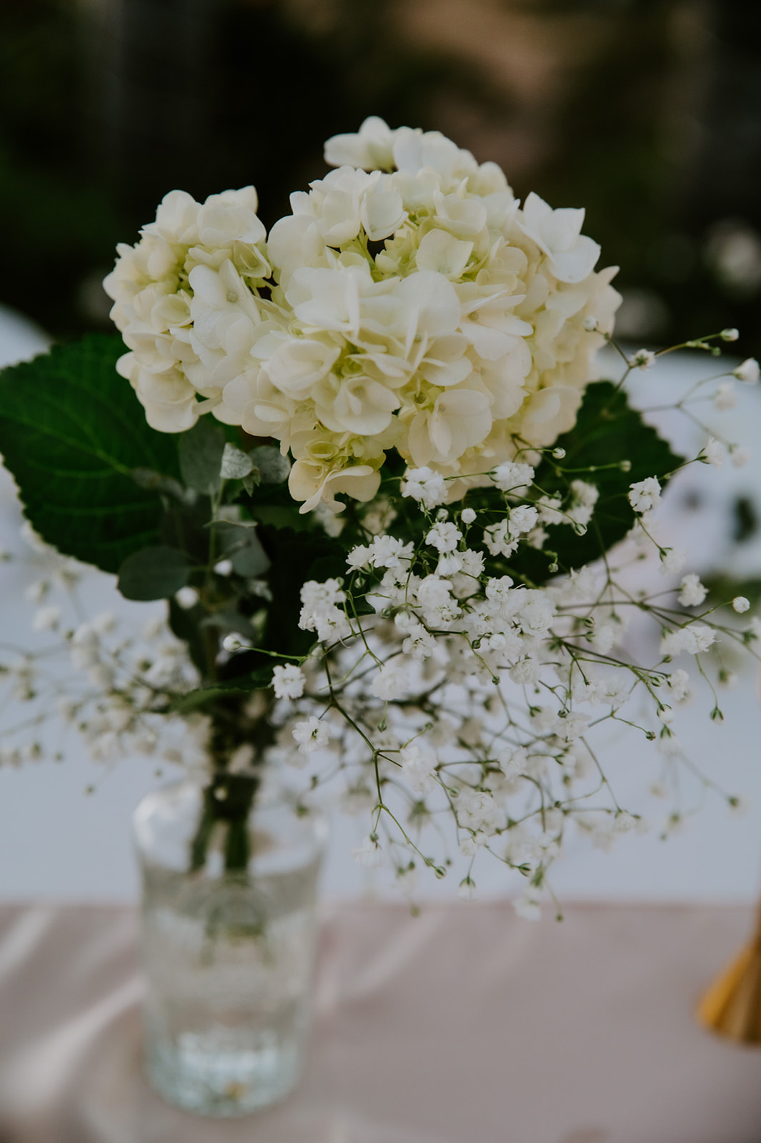 Simple white hydrangea bouquet in a glass vase, a minimal floral detail from a California elopement planned with family in mind.