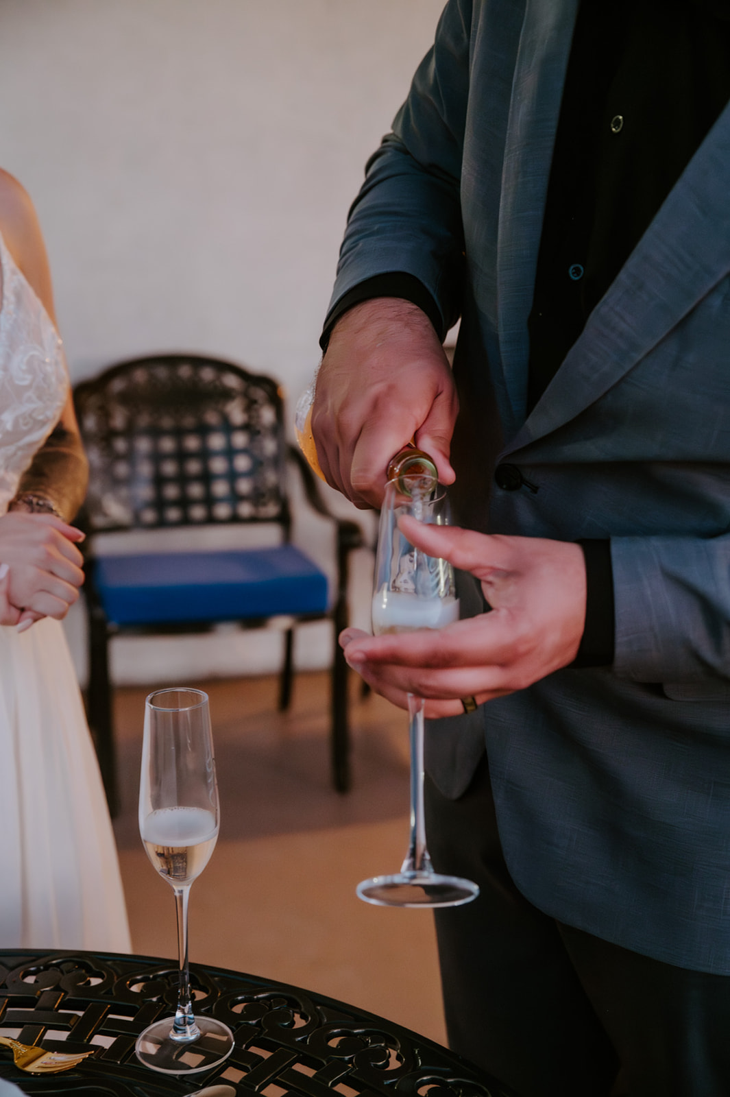 Groom pouring champagne during a relaxed Airbnb wedding reception, a small moment from how to plan an elopement with family that still feels celebratory.