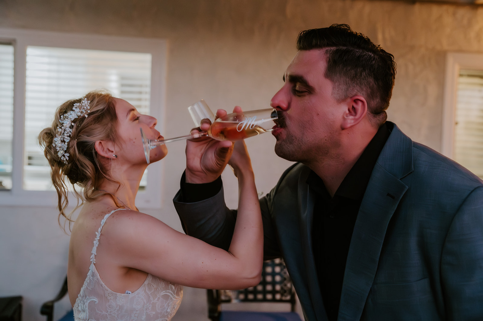 Bride and groom clinking champagne glasses during an Airbnb wedding reception, highlighting how to plan an elopement with family without losing the laid-back vibe.