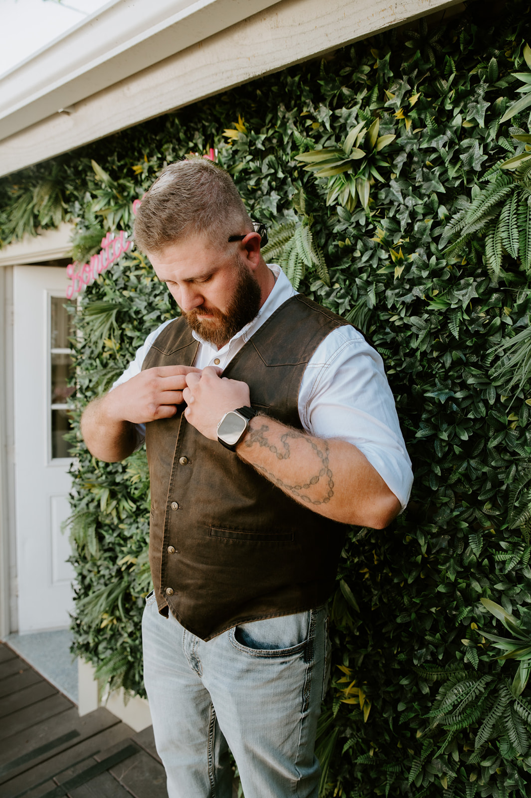 Groom adjusting wedding attire and brown vest before walking to the beach for their outdoor elopement. 