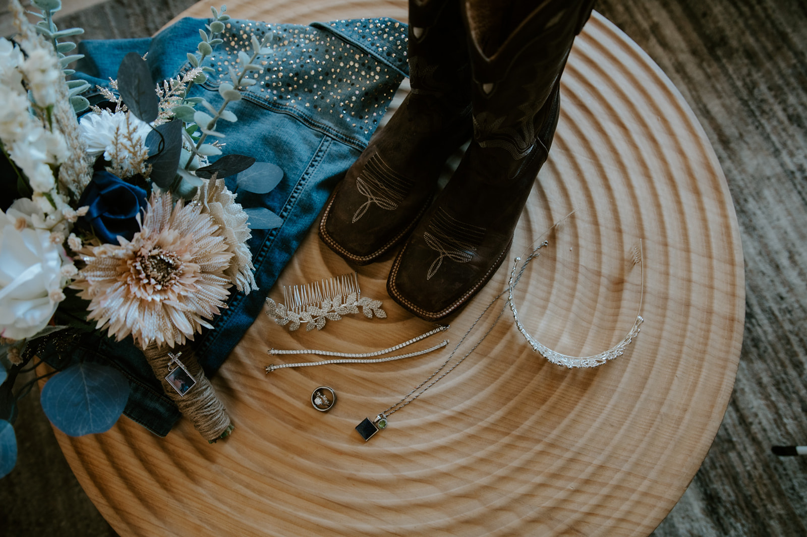 Flat lay of rustic elopement details of bridal accessories. Featuring cowboy boots, bridal bouquet and jewelry captured by California elopement photographer. 
