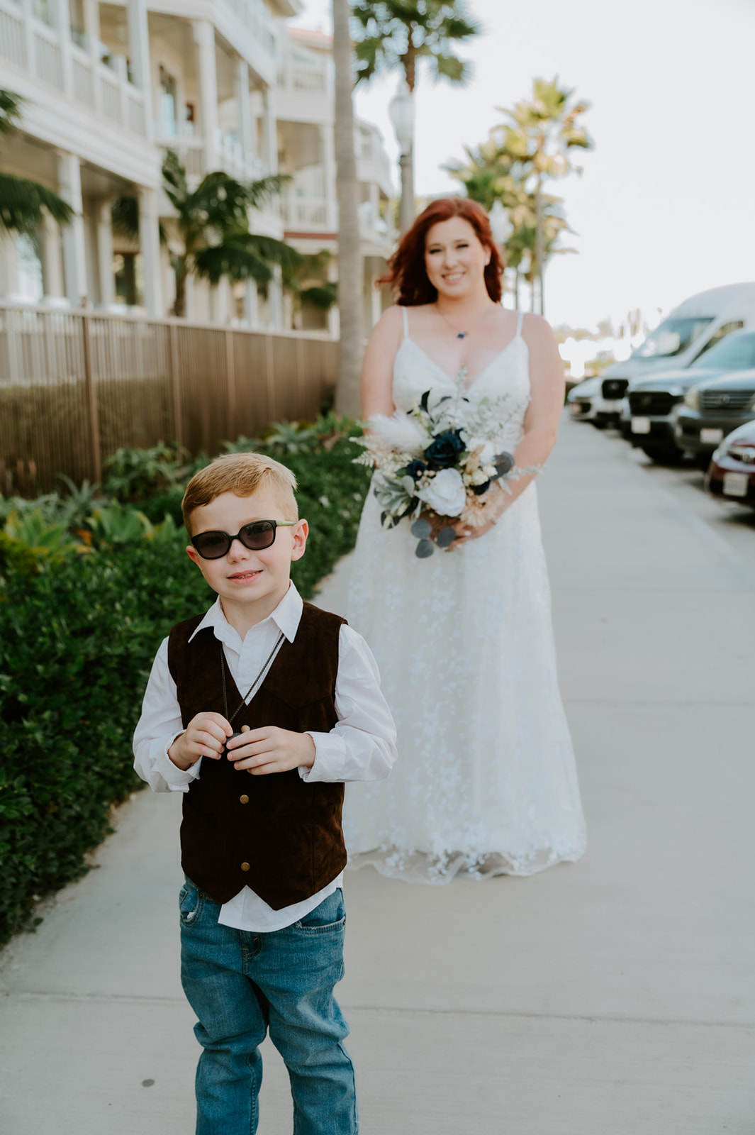 Young boy with his back to his mother before first look in her wedding dress. 