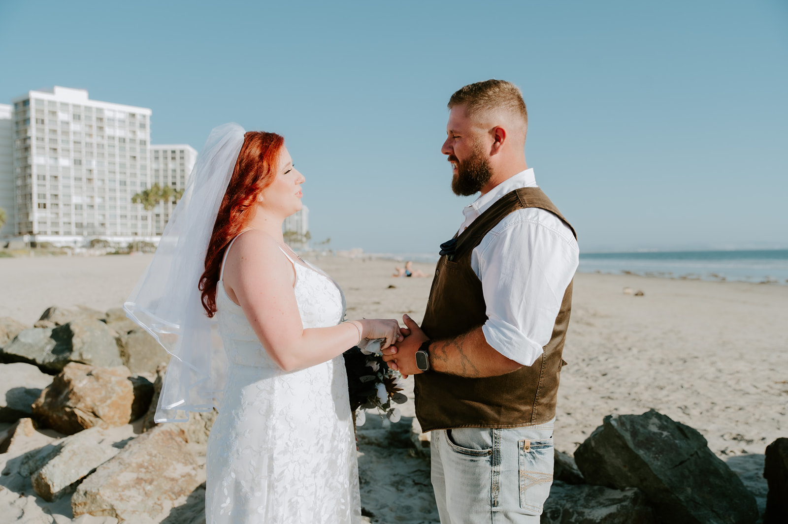Bride and groom holding hands during an intimate beach elopement ceremony in California, captured by a California elopement photographer