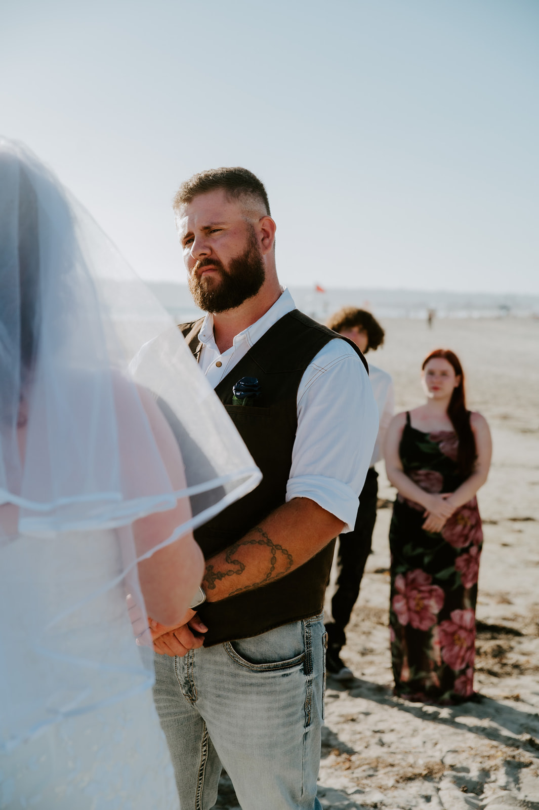 Groom standing and holding the bride's hands while she reads her vows. 