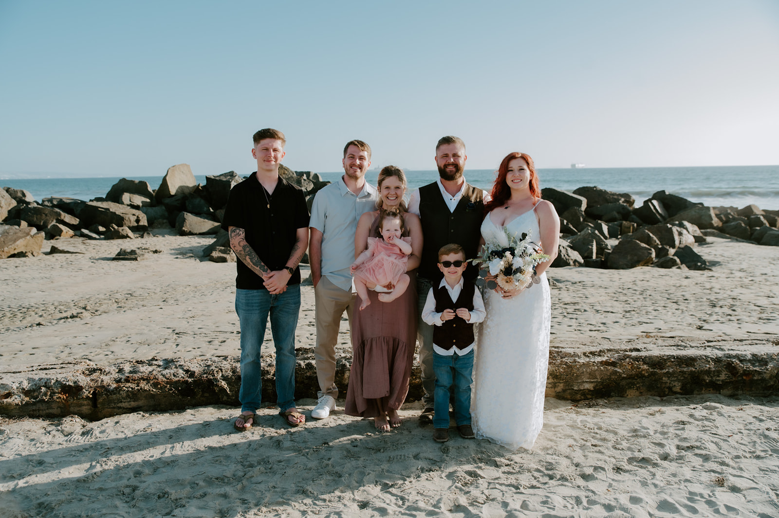 Bride and groom smiling after beach elopement during family photos taken by California elopement photographer