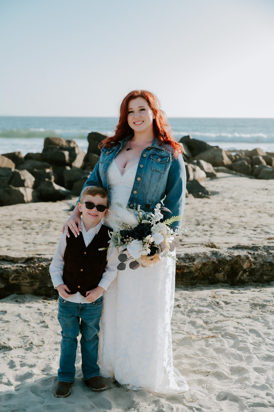 Bride smiling with young son after beach elopement captured by California elopement photographer.