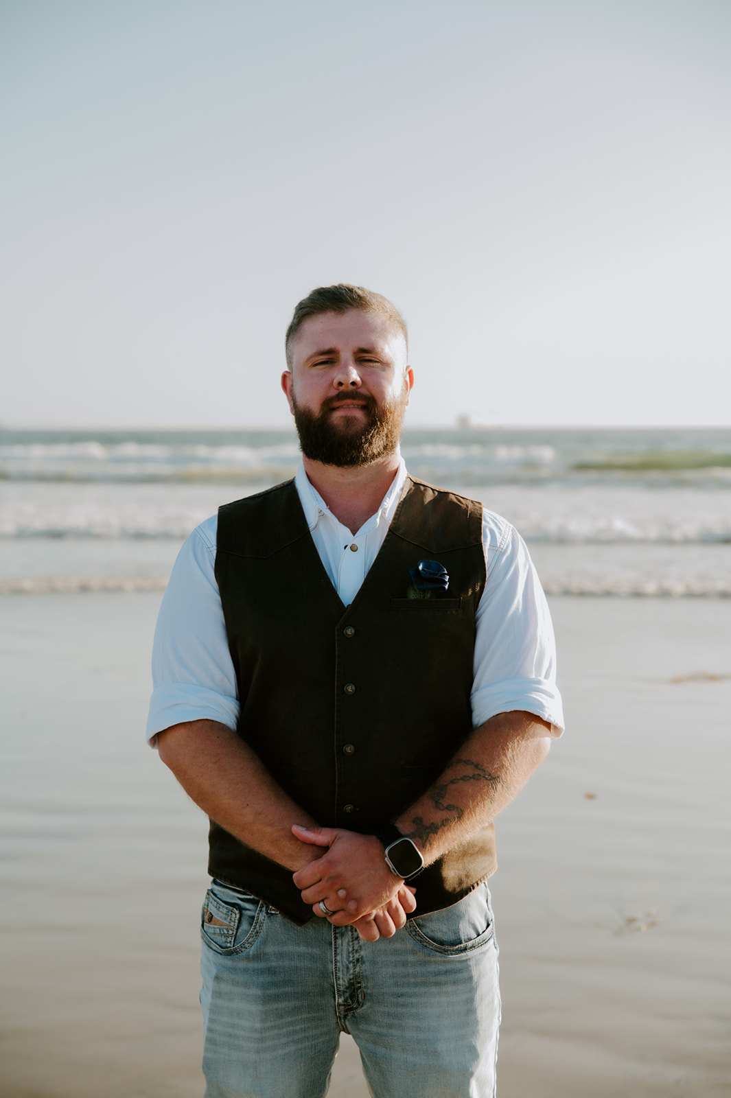 Groom standing alone on the shoreline before the ceremony during a California elopement.