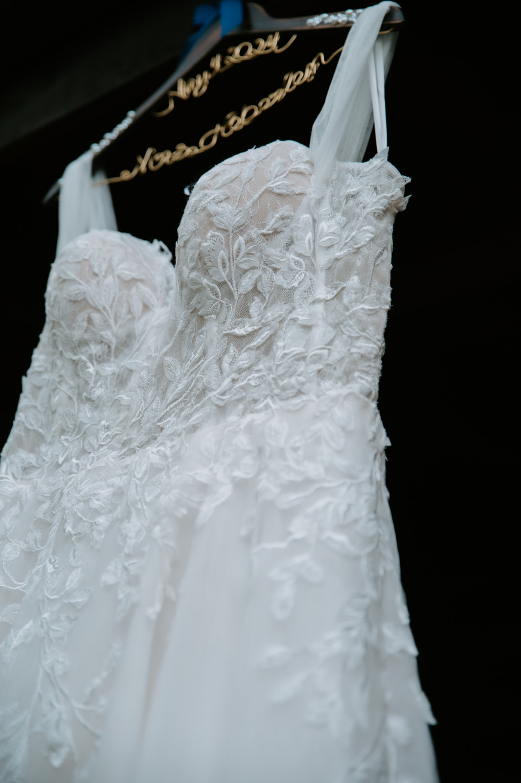 Lace wedding dress hanging in a cabin during a Smoky Mountain Elopement, showcasing delicate details and soft fabric in natural light.