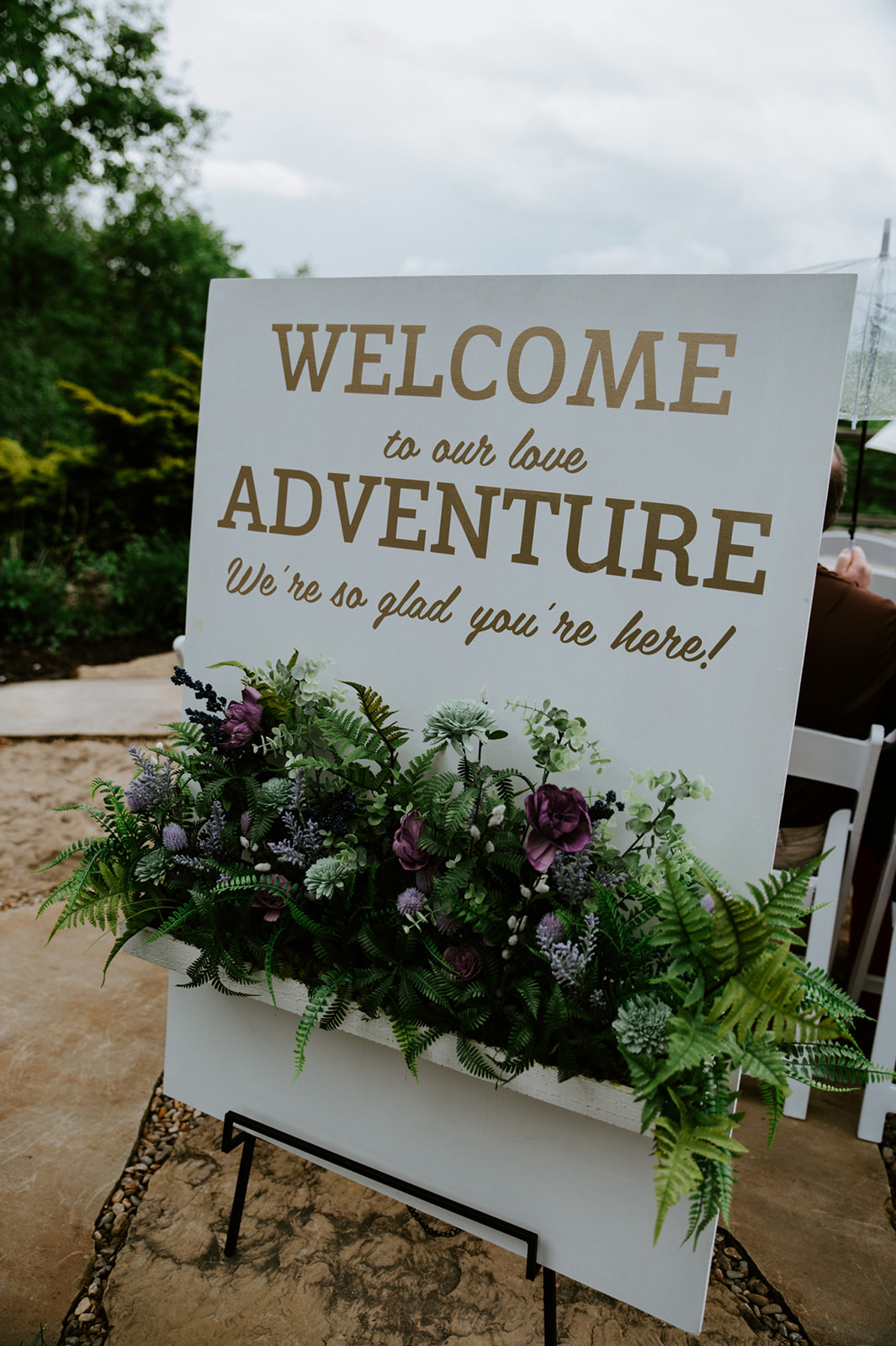 Welcome sign reading “Welcome to our love adventure” decorated with florals at a Smoky Mountain elopement ceremony.