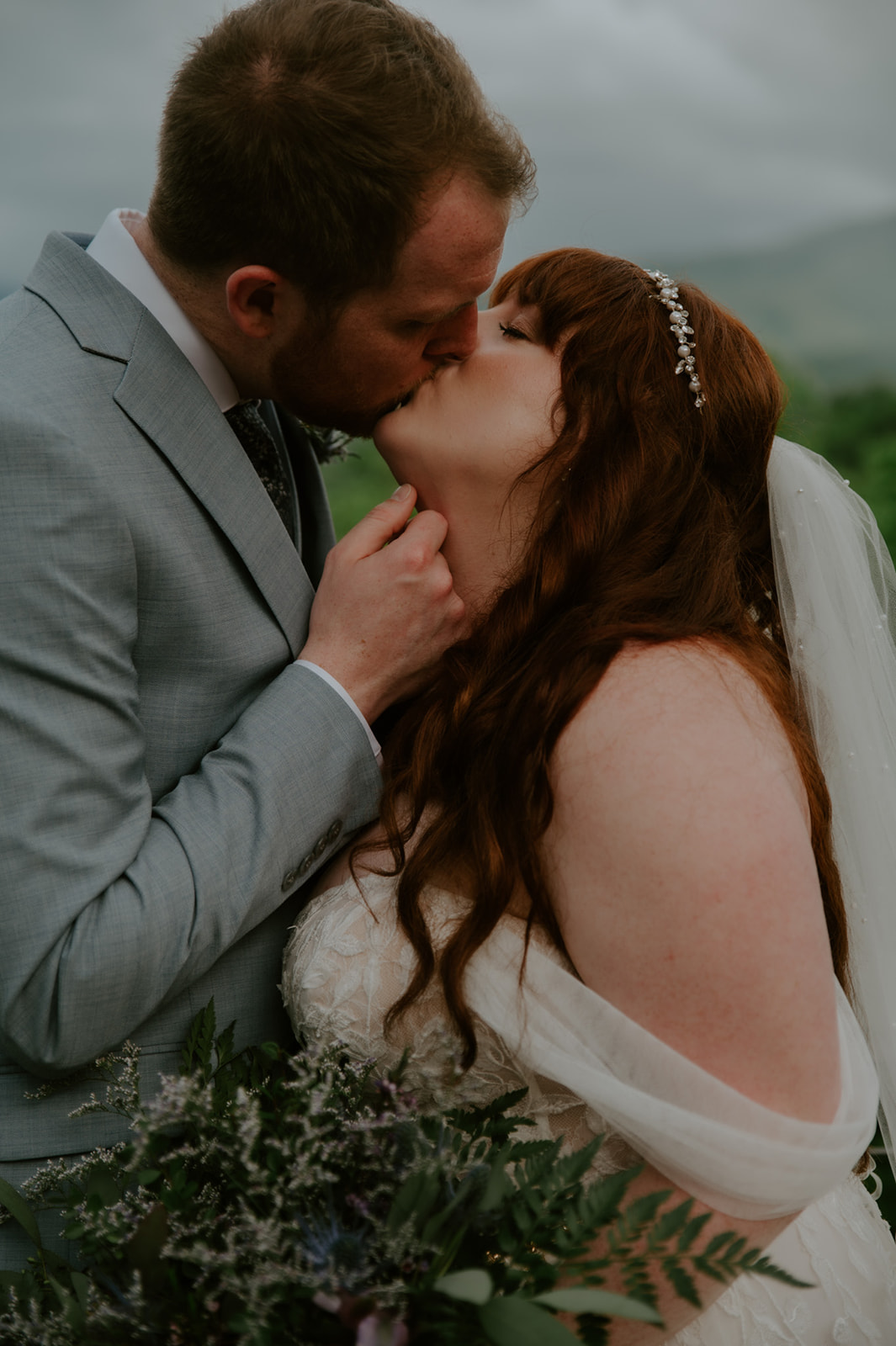 Intimate close-up of bride and groom sharing a kiss during their Smoky Mountain elopement, bouquet held between them.
