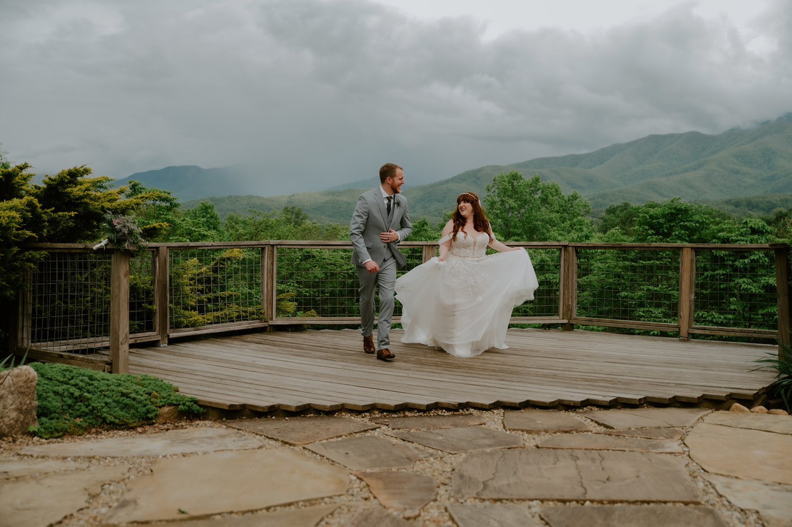 Bride and groom laughing and moving together on a mountain deck during their Smoky Mountain elopement