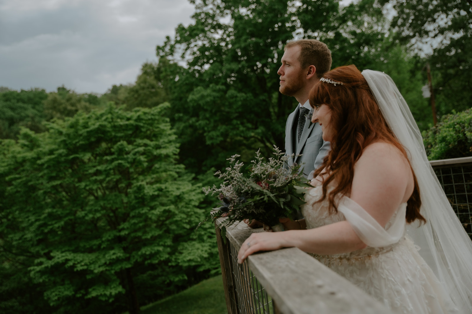 Couple leaning on a railing together, taking in the mountain view after their ceremony