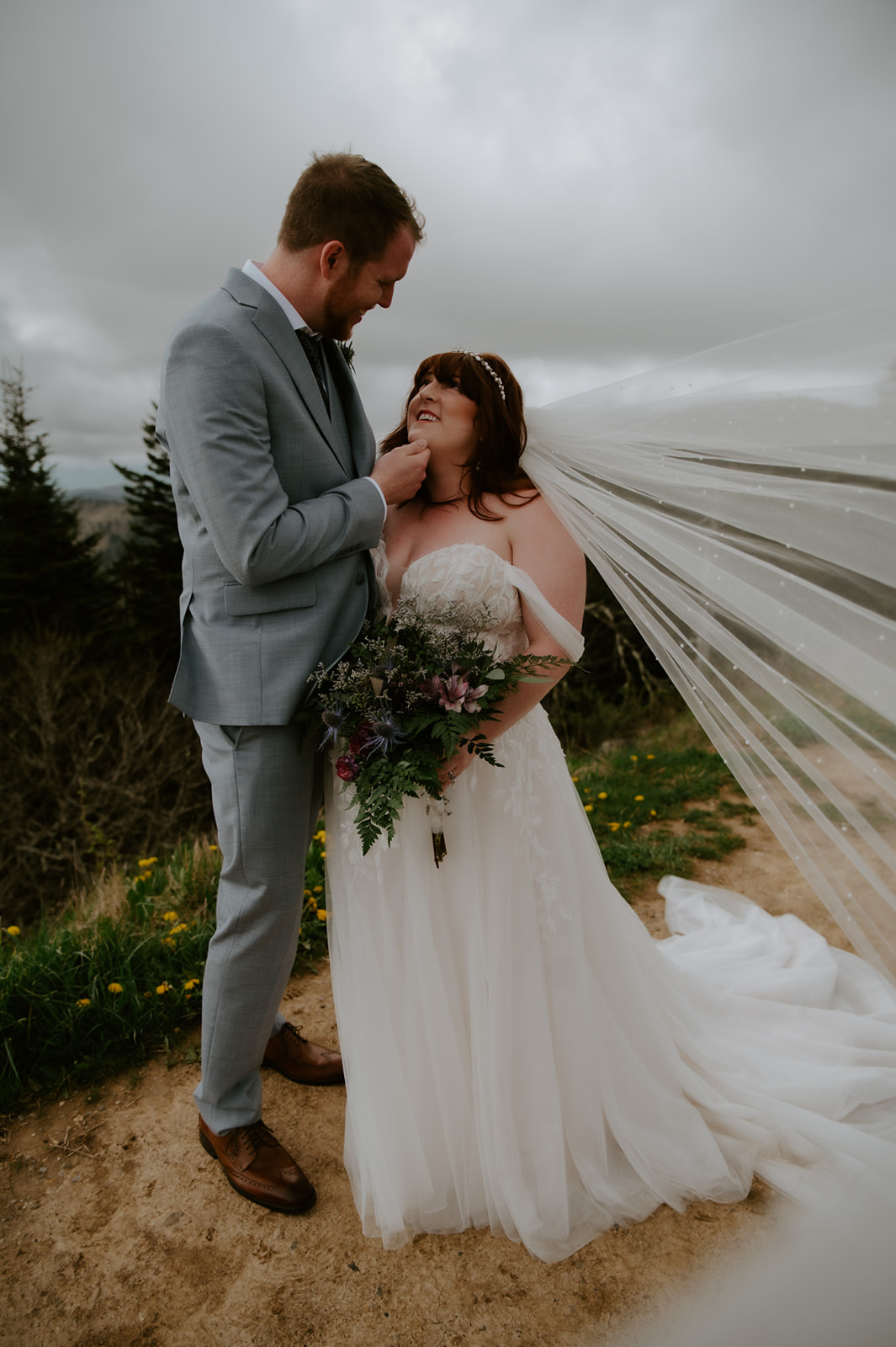 Romantic Smoky Mountain elopement portrait with the bride’s veil flowing in the wind