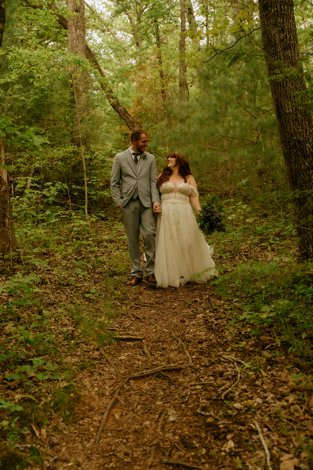 Couple walking hand in hand through the forest during a Smoky Mountain elopement photo session