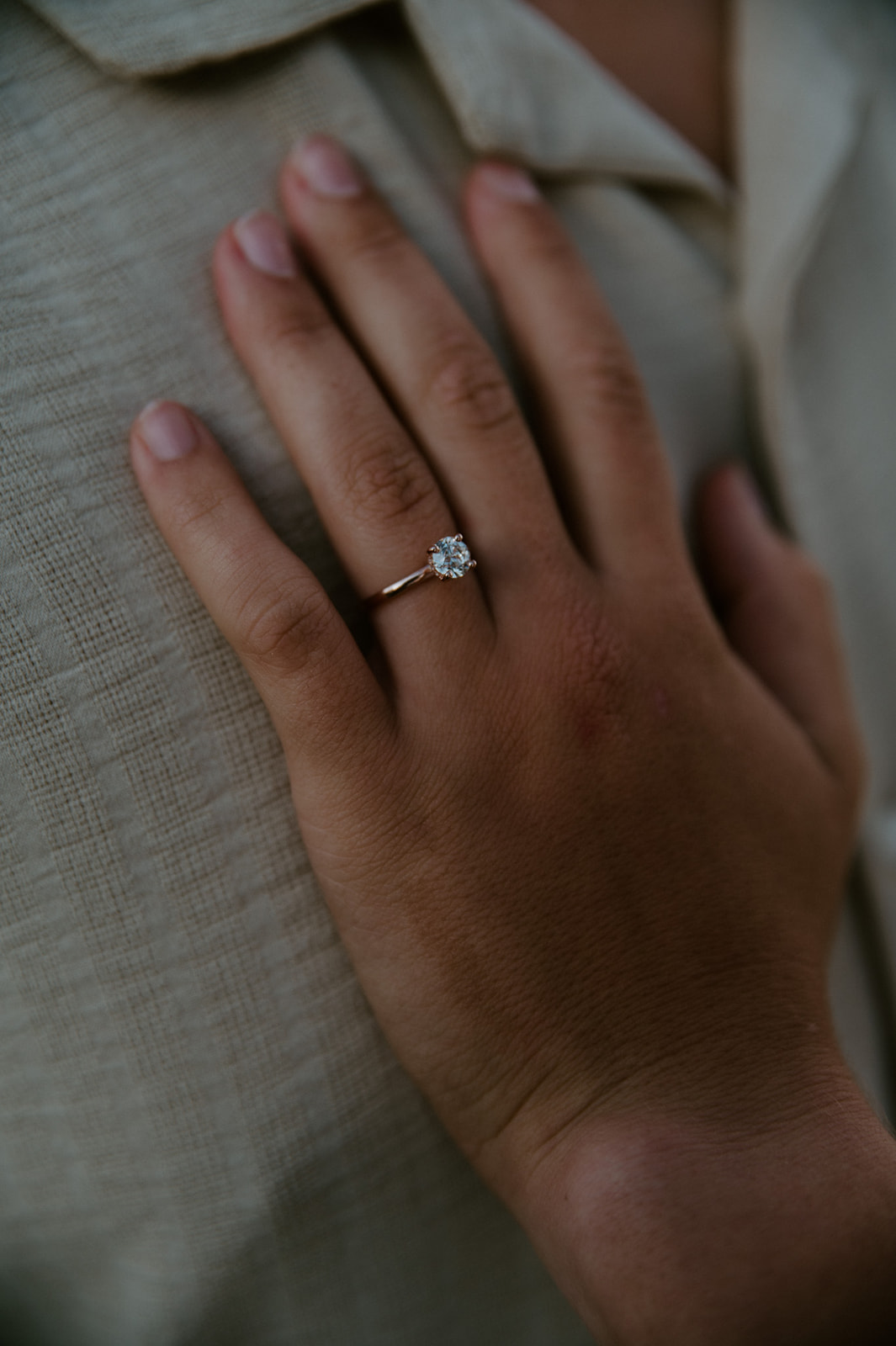 Close-up of an engagement ring resting on a partner’s chest during an intimate Washington elopement moment.