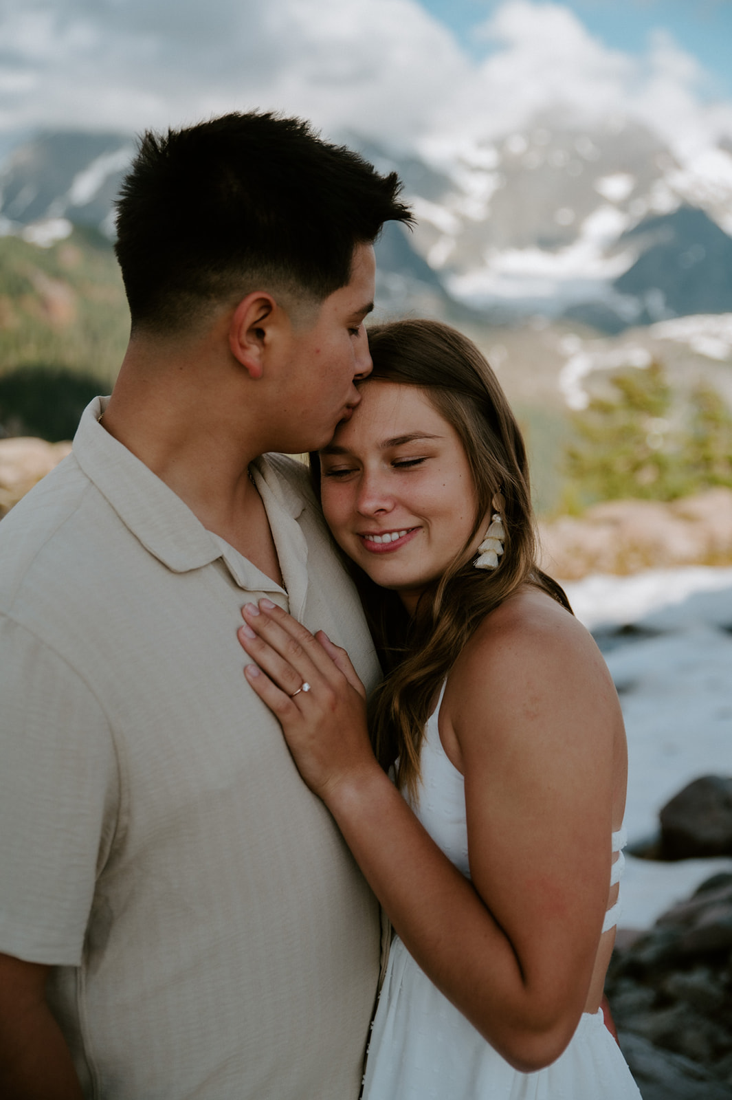 Bride resting her head on her partner’s chest during a quiet moment in the mountains on their Washington elopement day.