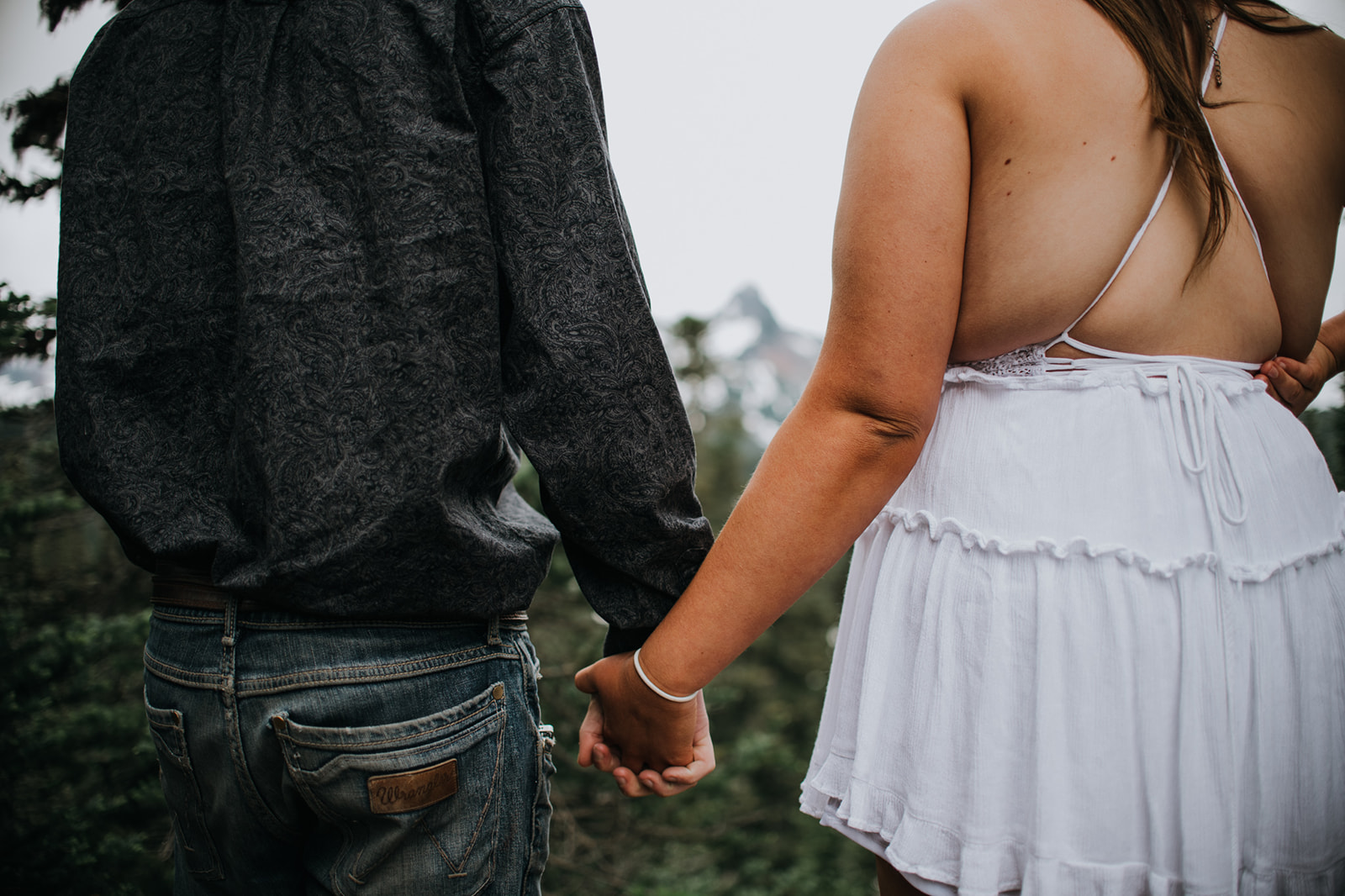 Close-up of a couple holding hands while walking through the forest during an intimate Washington elopement.