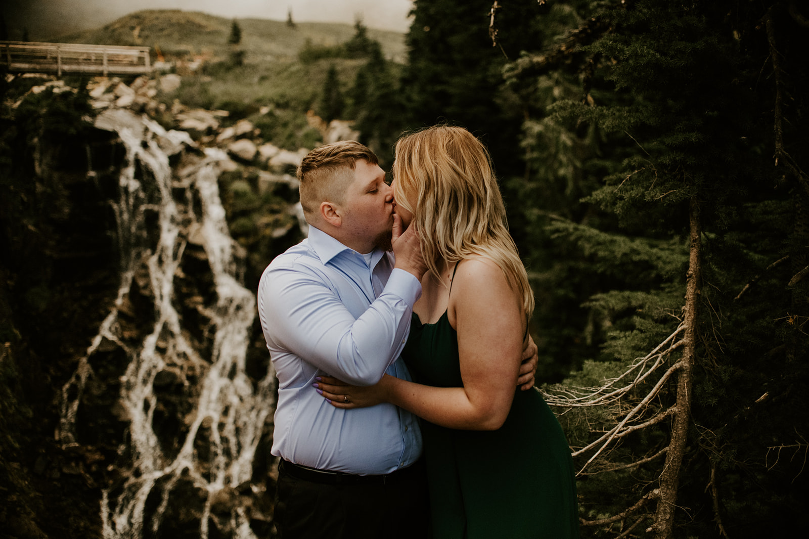 Couple embracing near a waterfall overlook during a romantic Washington elopement moment.
