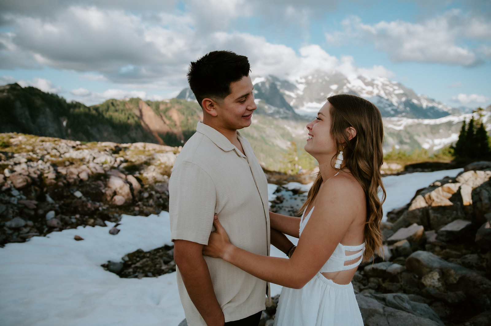 Couple facing each other and laughing in snowy alpine terrain during North Cascades elopement photos