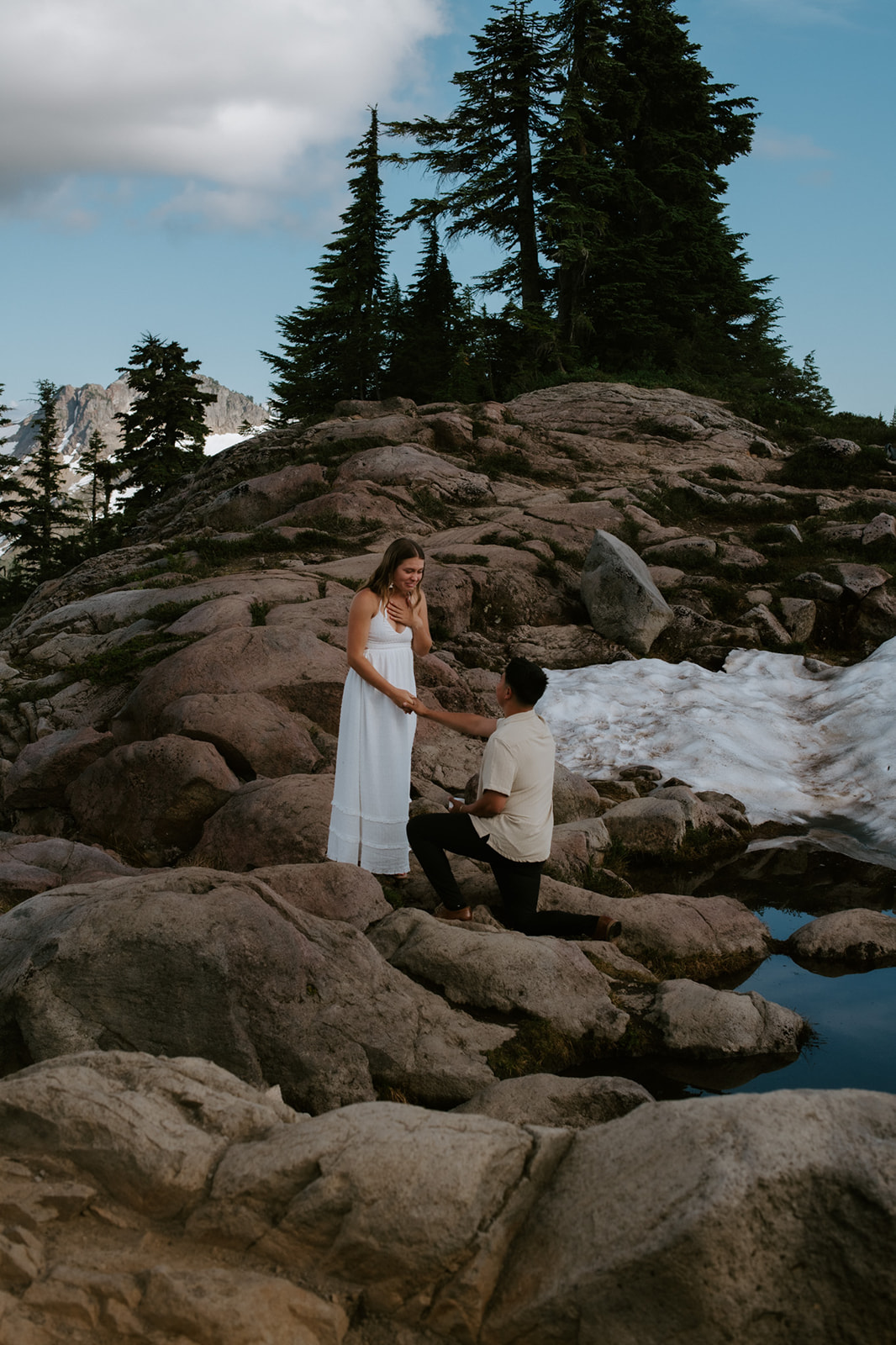 Woman covering her mouth in shock after surprise proposal before North Cascades elopement. 