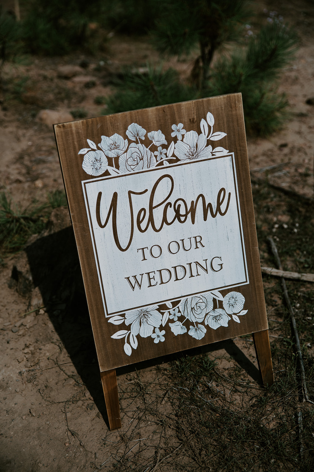 Wooden welcome sign placed in the forest for an intimate outdoor wedding in Arizona.