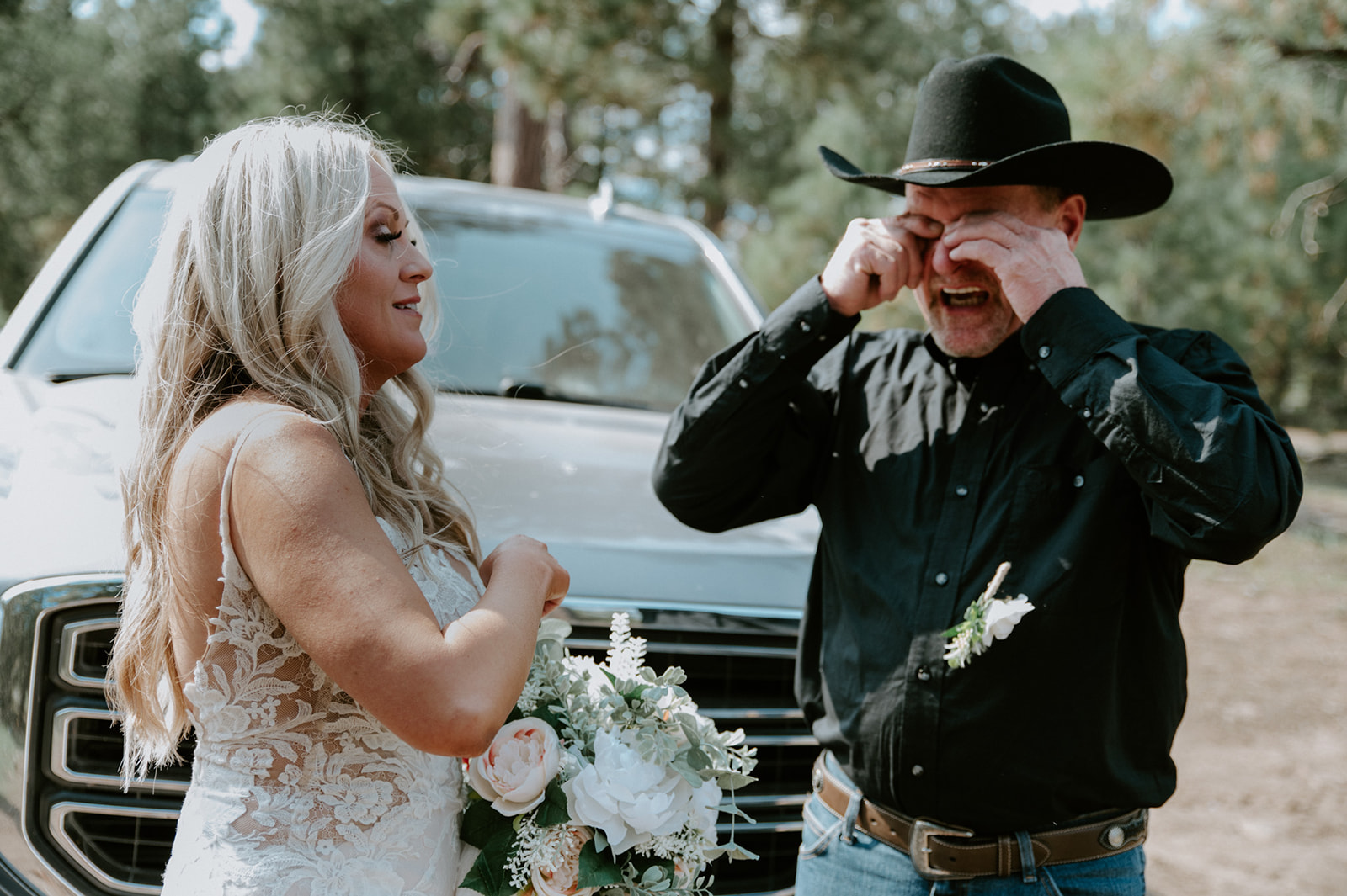 Bride holding her bouquet while a family member wipes away tears before the couple elopes in Arizona.