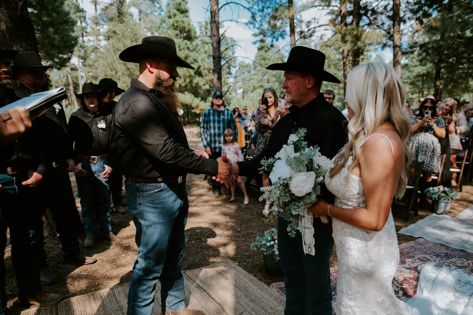 Groom shaking hands with the bride’s father during a heartfelt forest ceremony as they elope in Arizona.