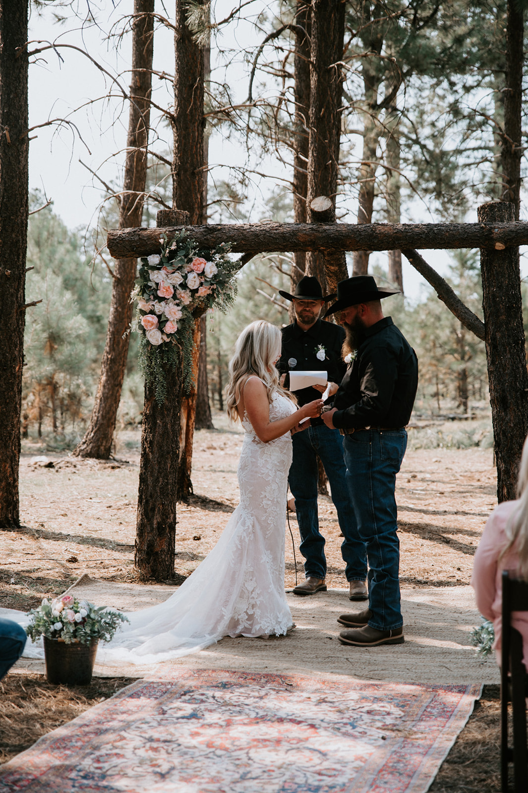 Bride and groom reading vows to one another during intimate forest wedding. 