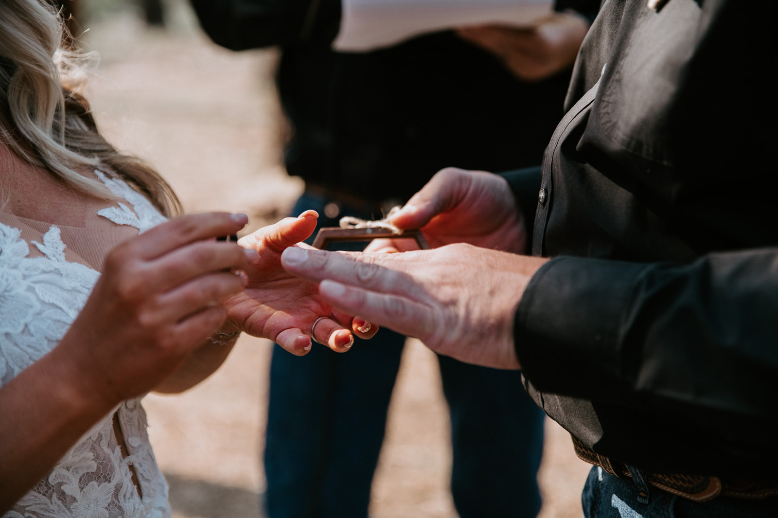 Close-up of groom placing a wedding ring on the bride’s finger during their intimate ceremony to elope in Arizona.