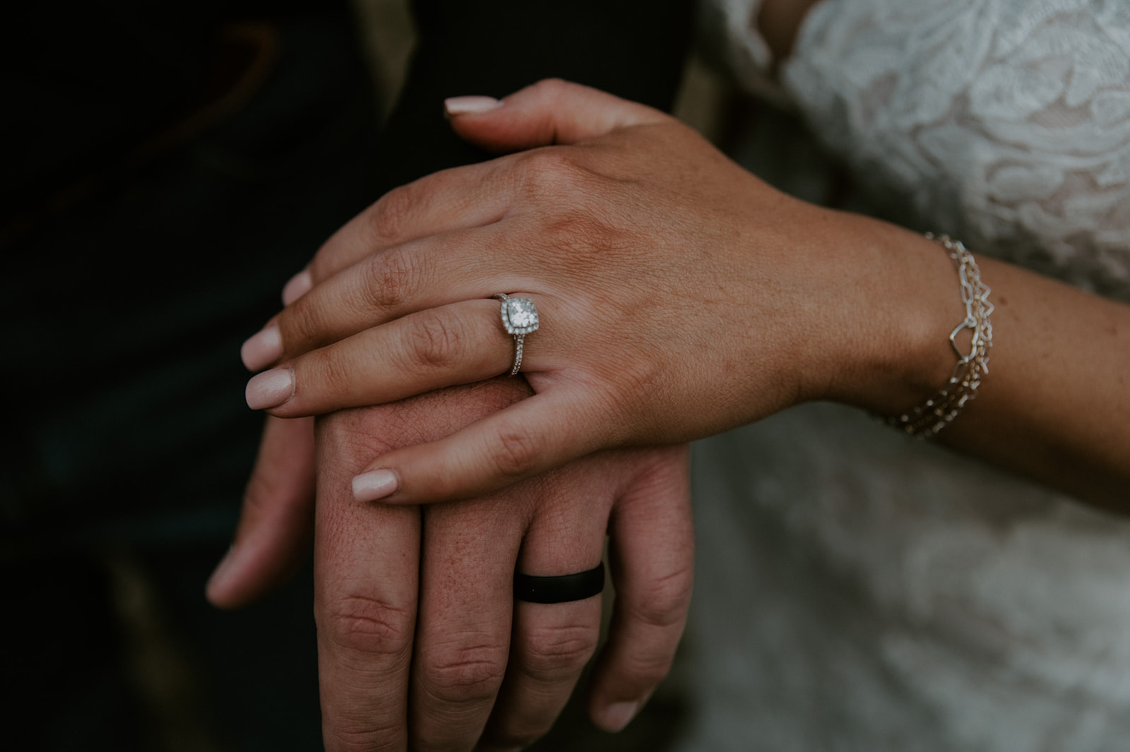 Close-up of bride’s engagement ring resting on groom’s hand during their intimate moment as they elope in Arizona.
