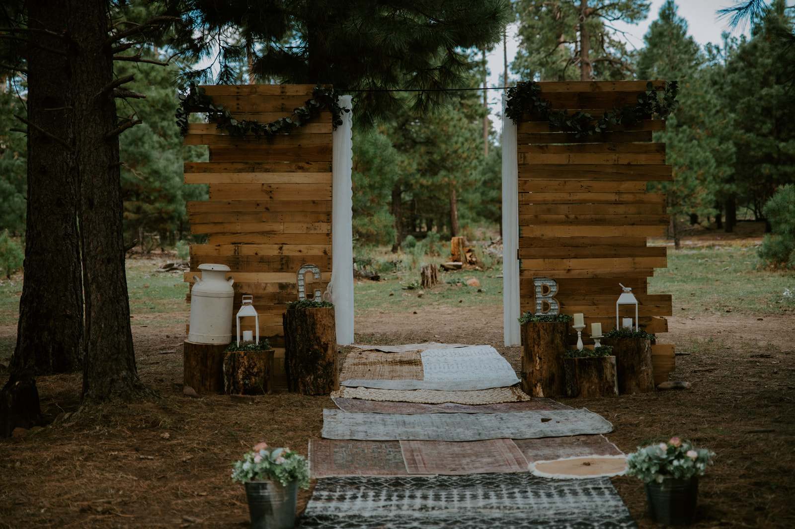 Rustic wooden ceremony backdrop set up in a quiet pine forest for a private place to elope in Arizona.