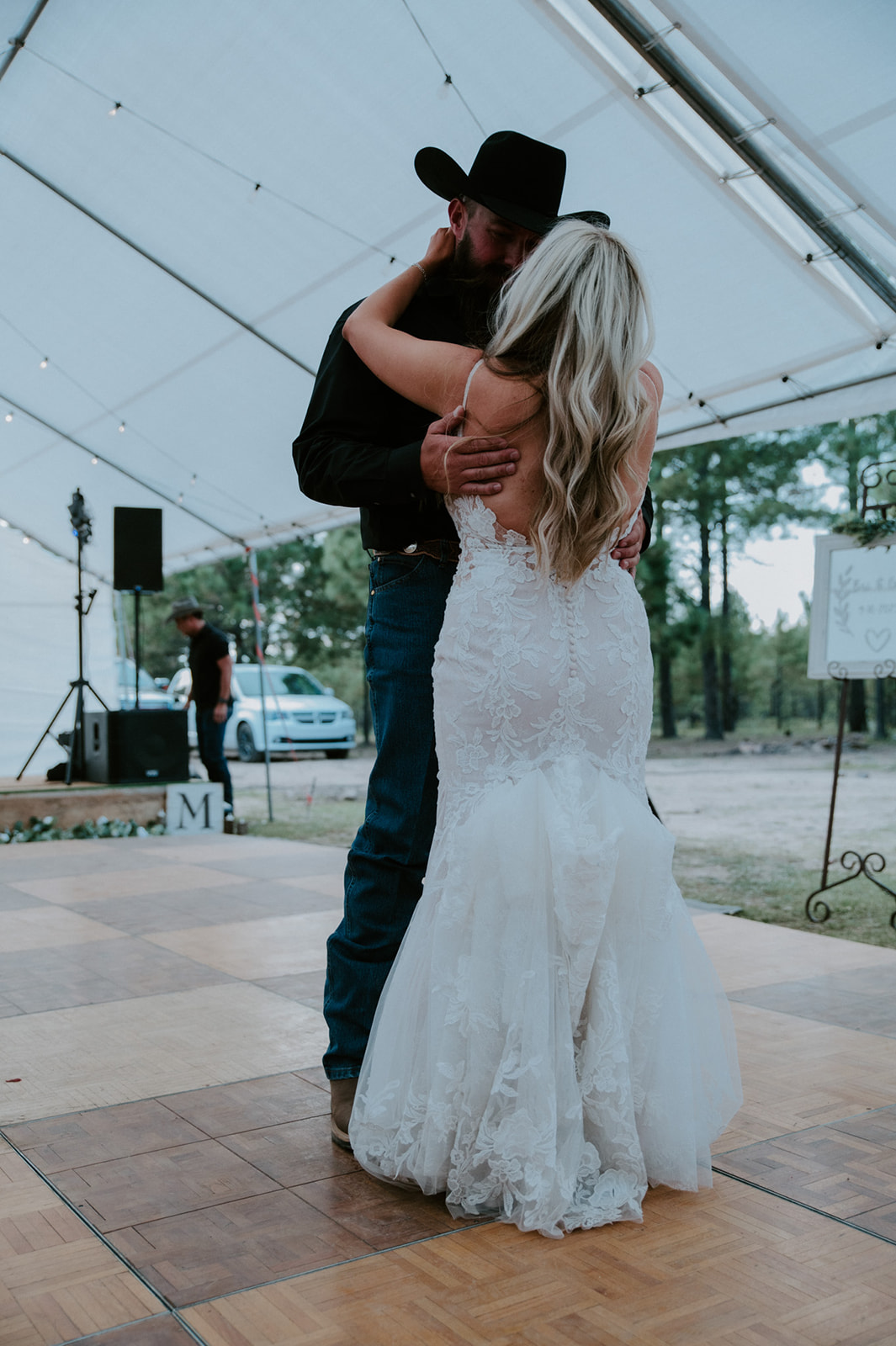 Bride and groom sharing their first dance under a white reception tent during their Arizona forest elopement.