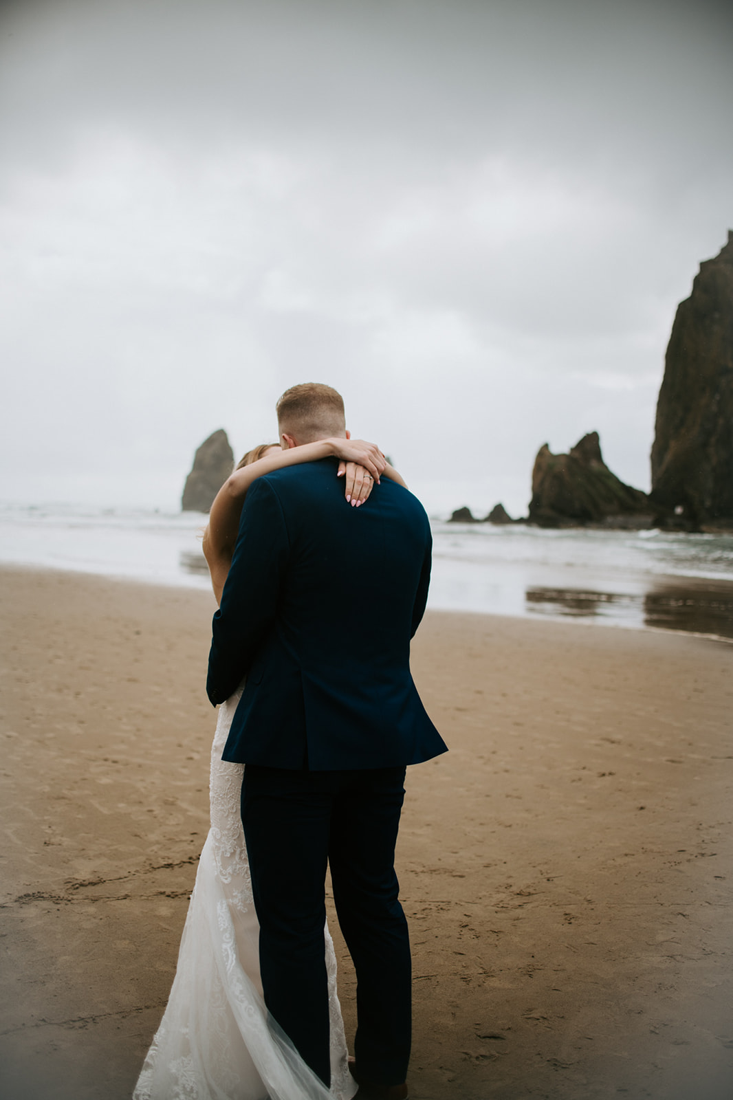 Bride and groom hug in an intimate moment on the beach after saying their vows to be husband and wife. 