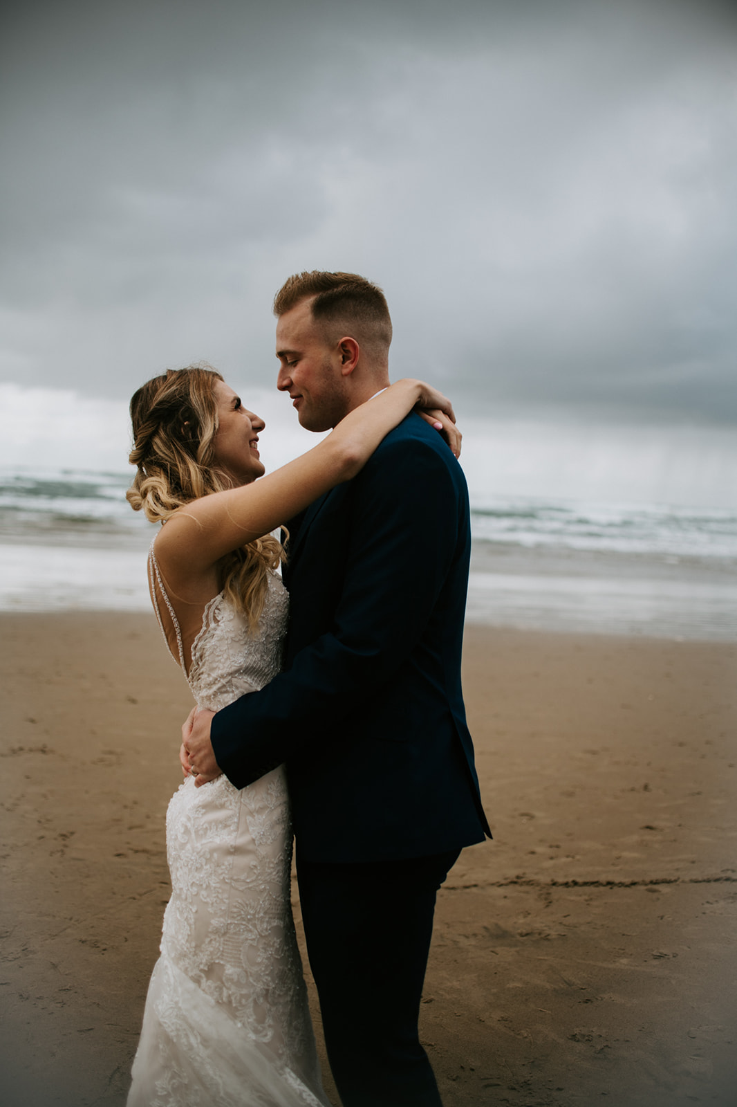 Bride's arms are wrapped around groom's neck as they smile and laugh together after their Oregon elopement. 