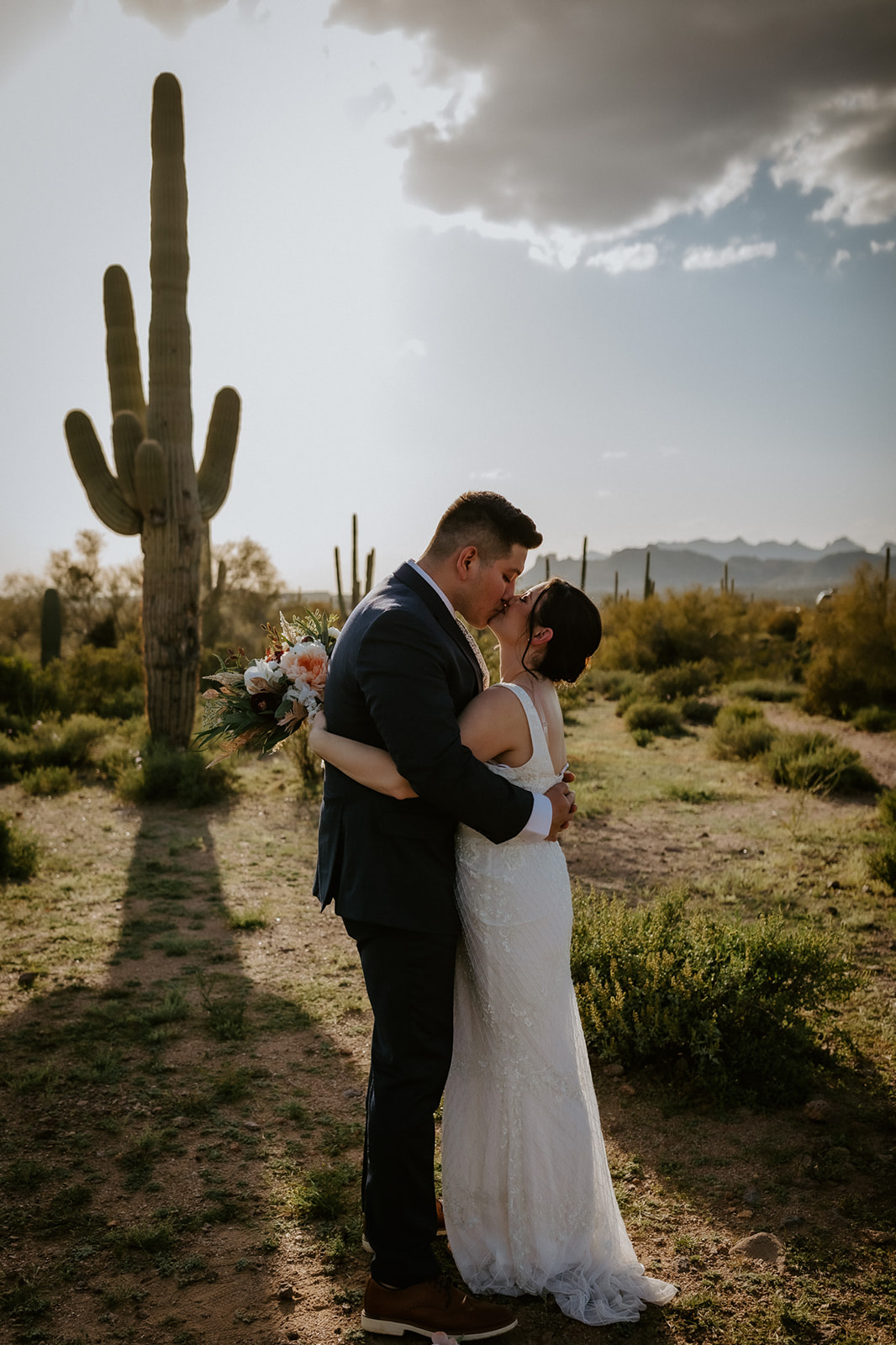 Arizona elopement kiss in the Sonoran Desert with cactus silhouettes and warm evening glow