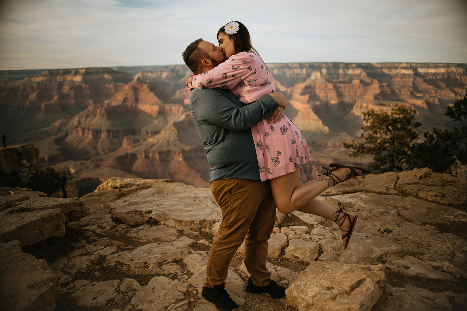 Playful Arizona elopement moment at the Grand Canyon as groom lifts bride on a cliffside overlook