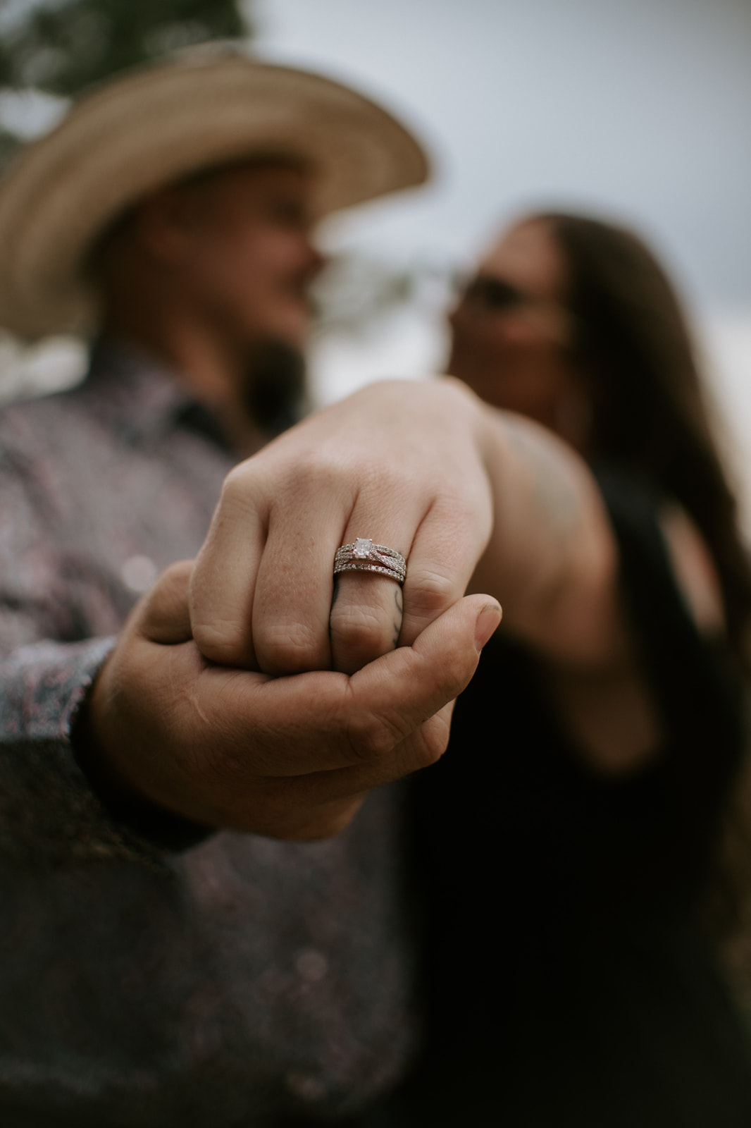 Arizona elopement ring detail shot with bride’s hand extended toward camera and partner softly blurred behind