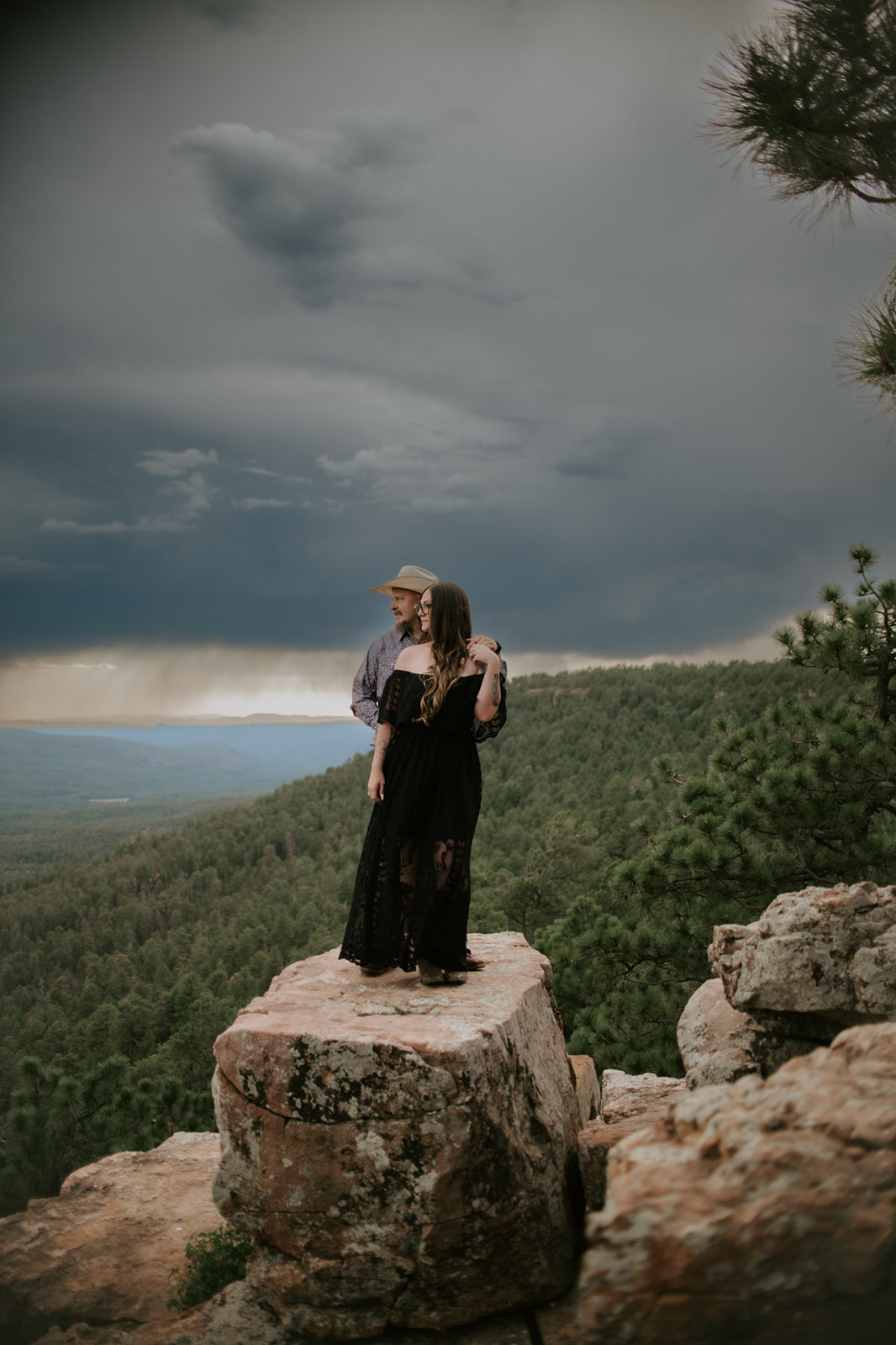 Bride and groom embracing in the desert with soft evening light and distant mountain silhouettes