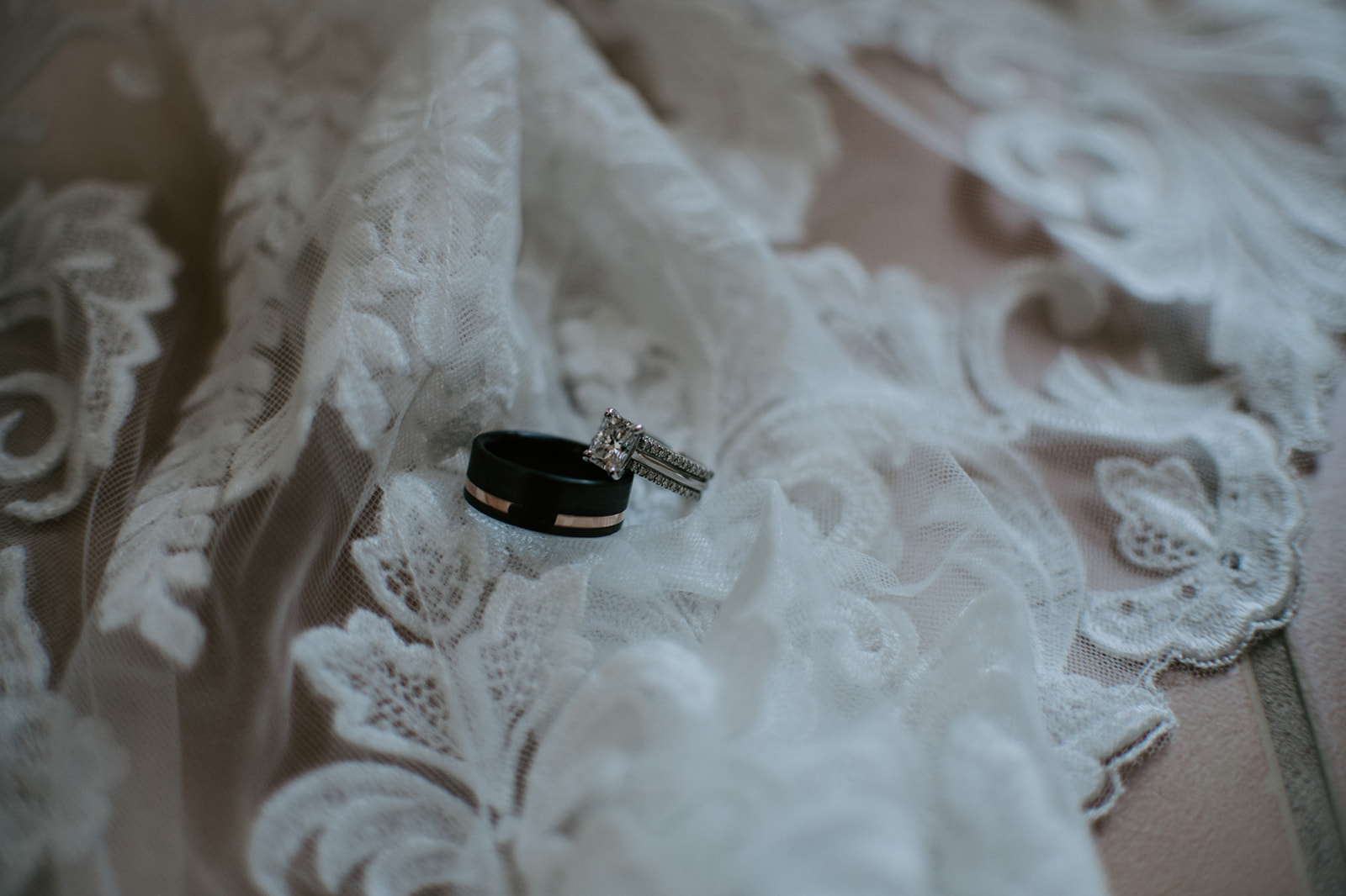 Wedding rings resting on lace dress fabric with soft natural light during an Arizona elopement morning
