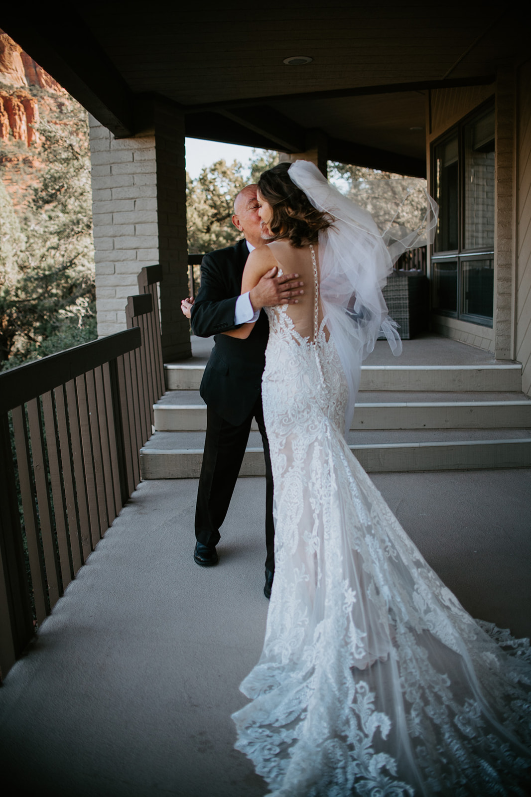 Bride and father sharing a hug on the balcony just before the ceremony
